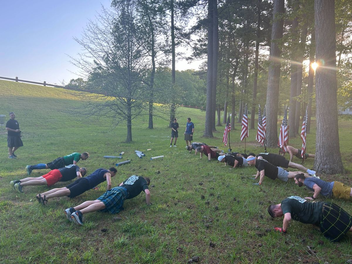F3 South Cary men doing push-ups in a park, several in kilts