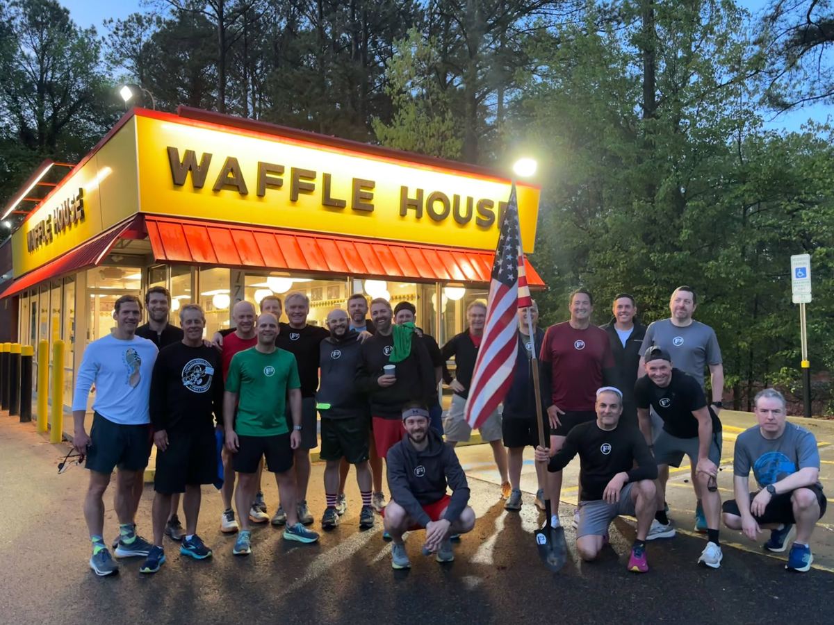 F3 South Cary men with an American flag in front of a Waffle House at dawn